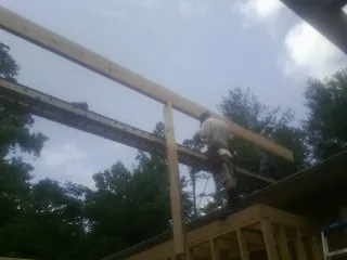 Carpenter setting a ridge beam over a new addition frame — Ice Dam Removal by Roofing Brothers in Willow Street