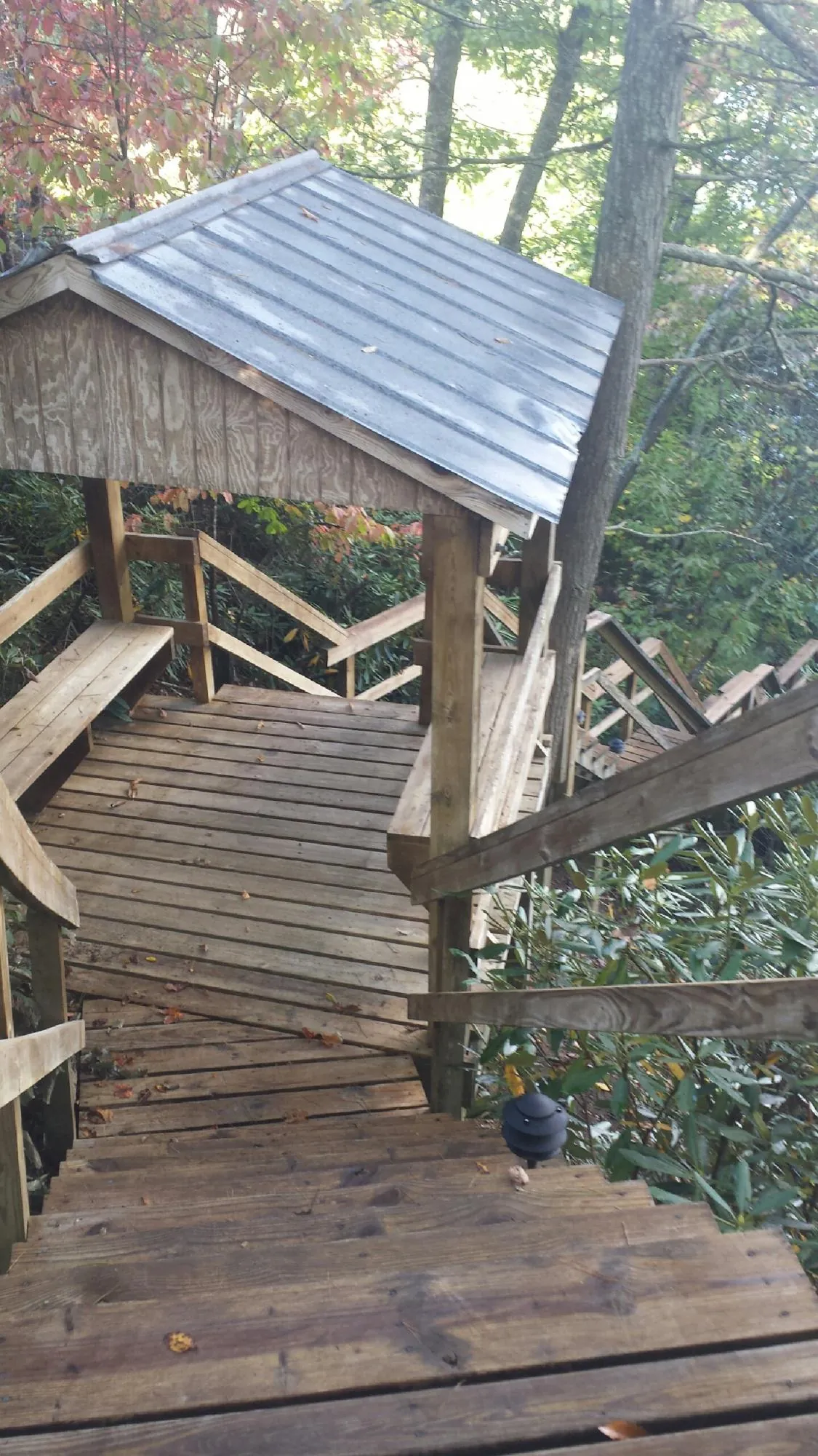 Metal roofed shelter over wooden steps on a wooded walkway — Skylight Repair & Installation work by our crew in Willow Street