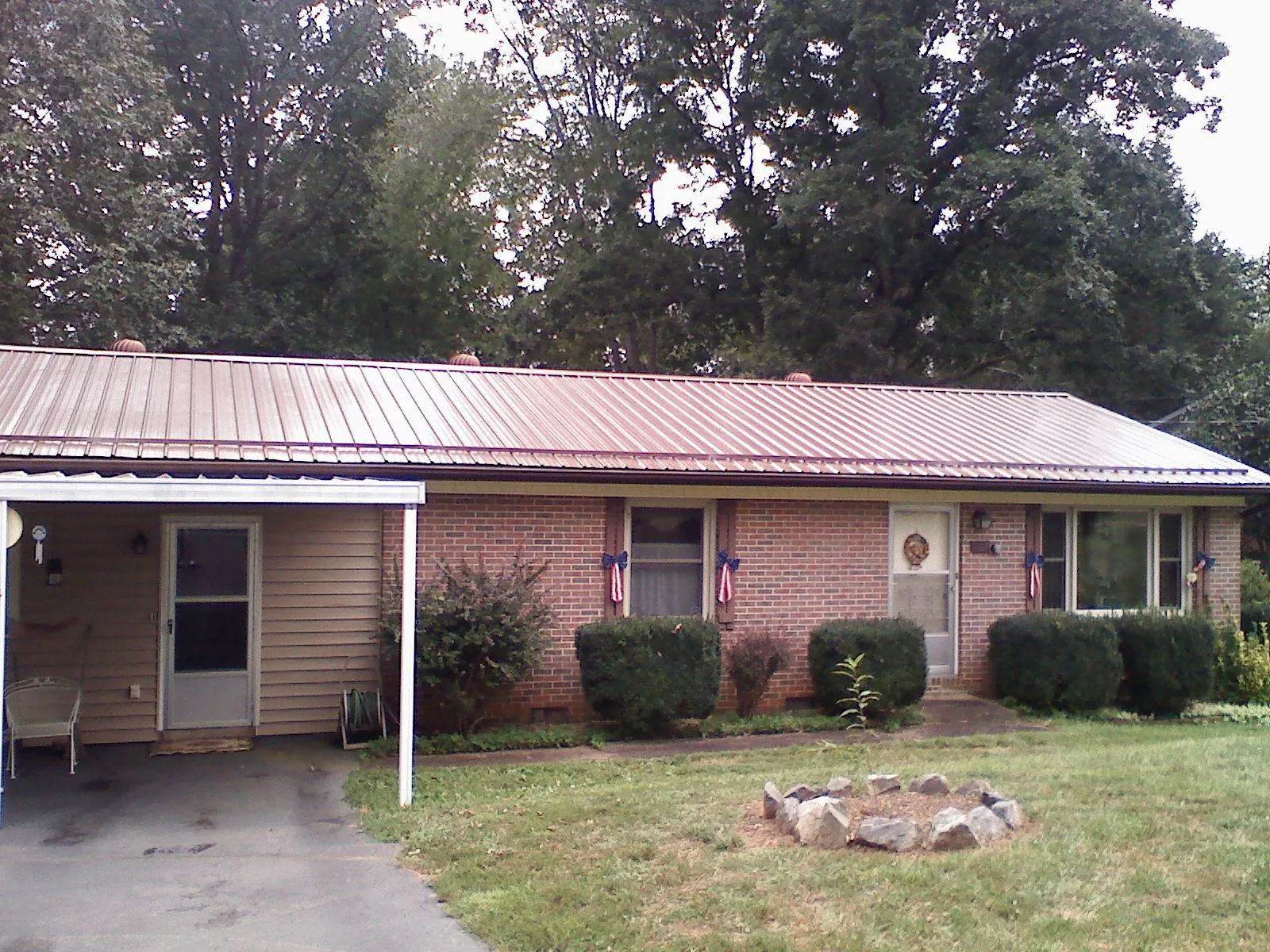 Bronze metal roof and carport on a brick ranch home — Roof Repair work by our crew in Willow Street